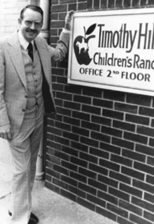 Jerry Hill Standing In Front of a Timothy Hill Sign